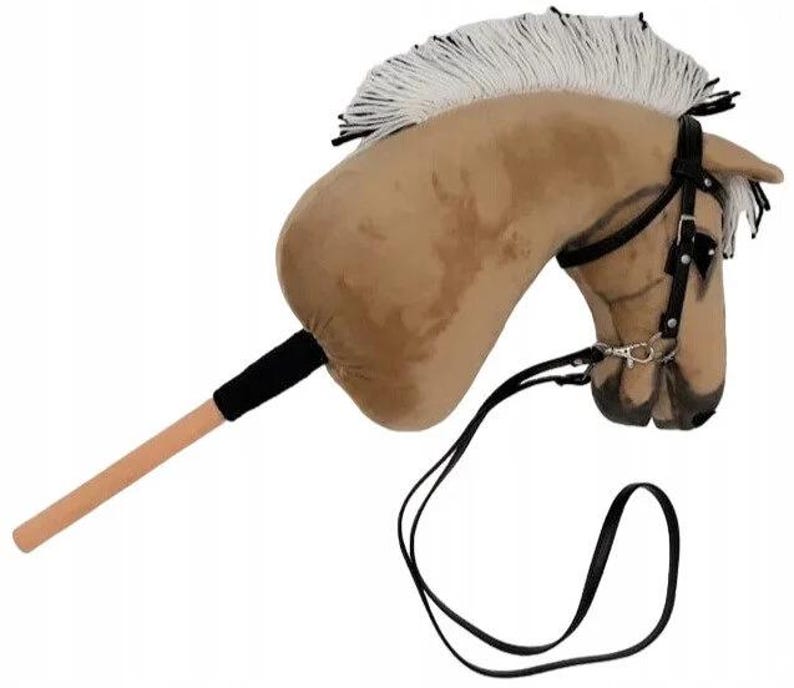 Pu&ograve; includere: Una testa di cavallo di peluche marrone e bianca con una briglia e redini nere. La testa del cavallo &egrave; attaccata a un bastone di legno.