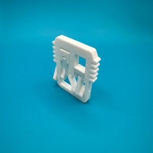 May include: White plastic 3D printed object shaped like a square with the word "REST" printed inside.