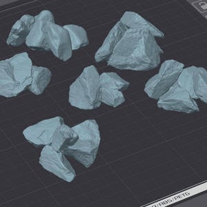 May include: Several light blue, irregularly shaped rock formations are arranged on a dark surface. The rocks vary in size and have a rough, textured appearance, suggesting a natural, weathered aesthetic. The arrangement appears to be a collection of individual pieces.