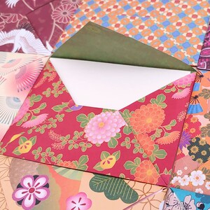 May include: A collection of paper envelopes featuring various colorful patterns, including floral motifs, fans, and geometric shapes in shades of red, orange, pink, blue, and green. One central envelope is open, revealing a plain white interior.