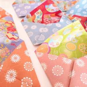 May include: A collection of origami envelopes with various floral patterns. The envelopes are made of colorful paper with different designs, including pink, blue, green, and orange.
