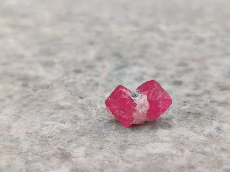 May include: A cluster of pink, translucent crystals with a slightly rough texture. The crystals are arranged in a loose, natural formation.