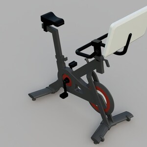 Puede incluir: Una bicicleta de ejercicio est&aacute;tica negra con un asiento acolchado blanco y una franja roja en la rueda. La bicicleta tiene un manillar negro con un soporte de tableta blanco.