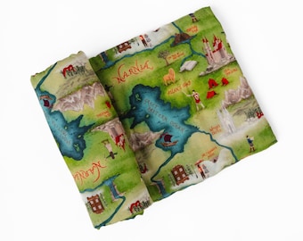 May include: A green and white map of Narnia, with red text and illustrations of castles, characters, and landmarks. The map is rolled up, showing details of the Great Eastern Ocean and other locations.