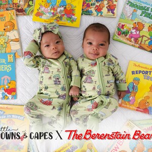 May include: Two babies in light green Berenstain Bears print onesies, with matching headbands, lying amongst children's books. The onesies have a zip closure. The books display colourful illustrations and titles such as "The Dentist" and "Trouble with Friends."