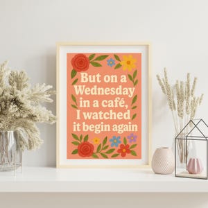 Può includere: Una stampa d'arte stampabile color pesca con un bordo floreale e il testo "But on a Wednesday in a café, I watched it begin again".