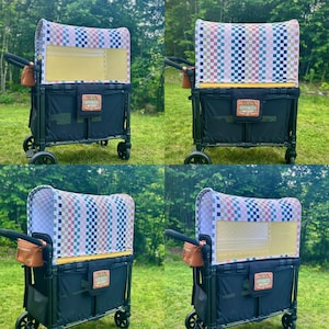 May include: A black collapsible utility wagon featuring a canopy with a multi-coloured checkered pattern in pink, blue, and tan. The wagon includes a black fabric body, a tan leather-like patch on the front, and a small brown storage pouch.