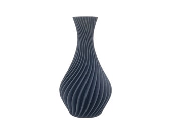 May include: A dark gray vase with a unique, textured design. The vase has a bulbous base that tapers to a slender neck. The surface features a series of vertical, swirling grooves, creating a visually appealing, decorative piece.