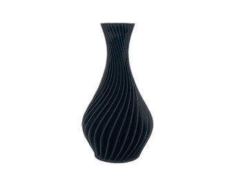 May include: A black ceramic vase with a swirling, textured design. The vase is tall and slender with a rounded base.