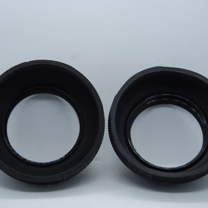 May include: Two black rubber lens hoods for camera lenses.