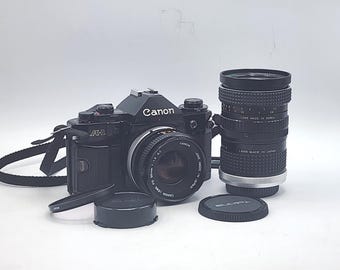 Canon A-1 Black Slr Film Camera w/ Canon FD 50mm f1.8 S.C., Aqunon Automatic f2.8 28mm Lens, MC Tokina Doubler for C/FD