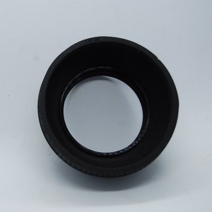 May include: Black rubber lens hood with the word "JAPAN" printed on the top.