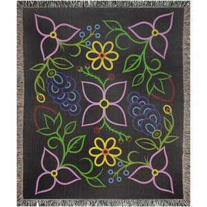 May include: A black woven throw blanket with a colorful floral pattern. The pattern features pink, yellow, green, blue, and red flowers and leaves.
