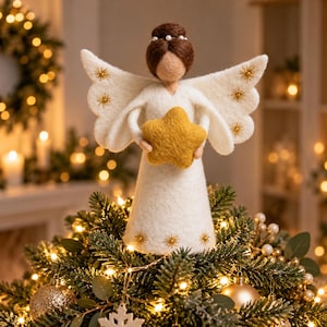 May include: A felt angel figurine with brown hair styled in a bun with white beads, wearing a white gown. The angel has white wings with gold star embroidery and holds a yellow felt star. The base of the gown features gold star accents.