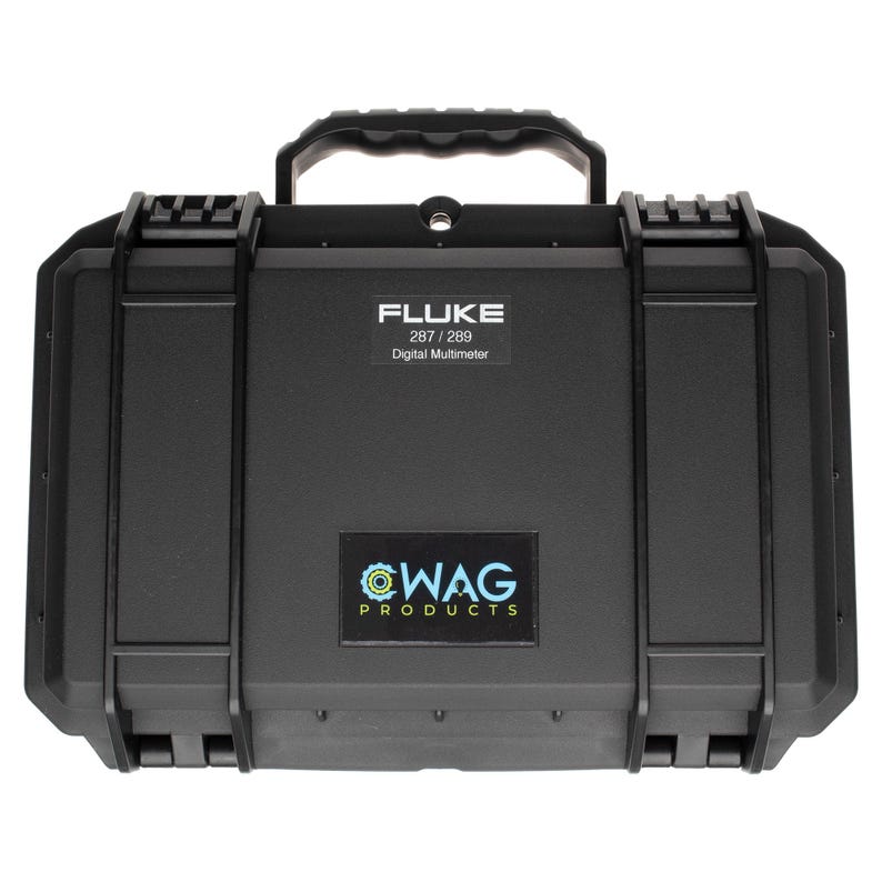 Puede incluir: Un malet&iacute;n de transporte r&iacute;gido y rectangular de color negro con un asa superior y dos cierres laterales. El malet&iacute;n presenta una etiqueta que dice FLUKE 287 / 289 Digital Multimeter y una segunda etiqueta con el texto WAG PRODUCTS en letras azules y blancas.