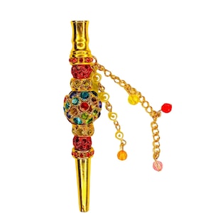 May include: A gold-colored metal pipe with a decorative, multi-colored jeweled sphere in the center. The pipe has a chain with small, colorful beads hanging from it.