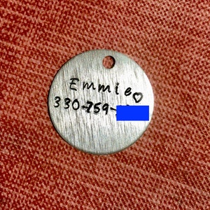 May include: Silver dog tag with the name "Emmi" and phone number "330-759-" followed by a heart symbol.
