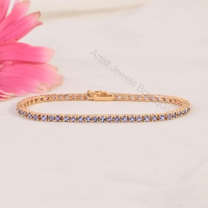 Può includere: Un bracciale tennis in oro rosa caratterizzato da una fila continua di piccole pietre preziose rotonde color viola chiaro incastonate in una montatura di metallo. Il bracciale include una chiusura sicura e il testo Artist Jewels Boutique.