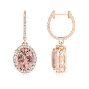 Puede incluir: Pendientes colgantes de oro rosa con una gran morganita ovalada rodeada por un halo de diamantes más pequeños. Los pendientes tienen un cierre de aro.