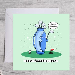 Puede incluir: Tarjeta de cumplea&ntilde;os verde claro con tem&aacute;tica de golf de dibujos animados. Presenta una bolsa de golf azul con una cara sonriente, palos de golf, una pelota y una bandera roja. El texto dice "Happy Birthday" y "best fianc&eacute; by par".