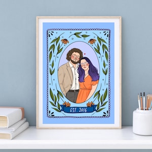 May include: A framed digital illustration featuring a couple inside an oval border decorated with green leaves and orange flowers. The person on the left has curly brown hair and glasses, wearing a tan blazer. The person on the right has long purple hair and glasses, wearing an orange dress. A blue banner at the bottom reads EST. 2016.