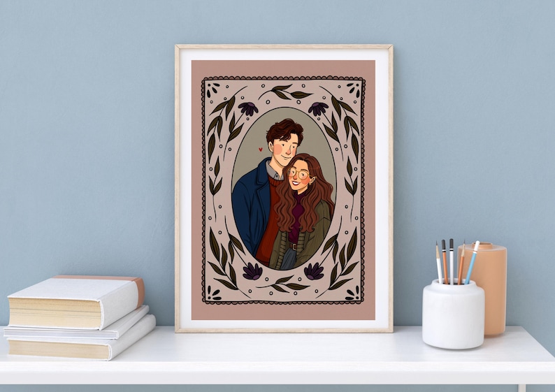 May include: A framed digital illustration featuring a couple in an oval portrait. The person on the left wears a dark blue coat over a red sweater, while the person on the right has long brown hair, glasses, and a green jacket. The border is floral.
