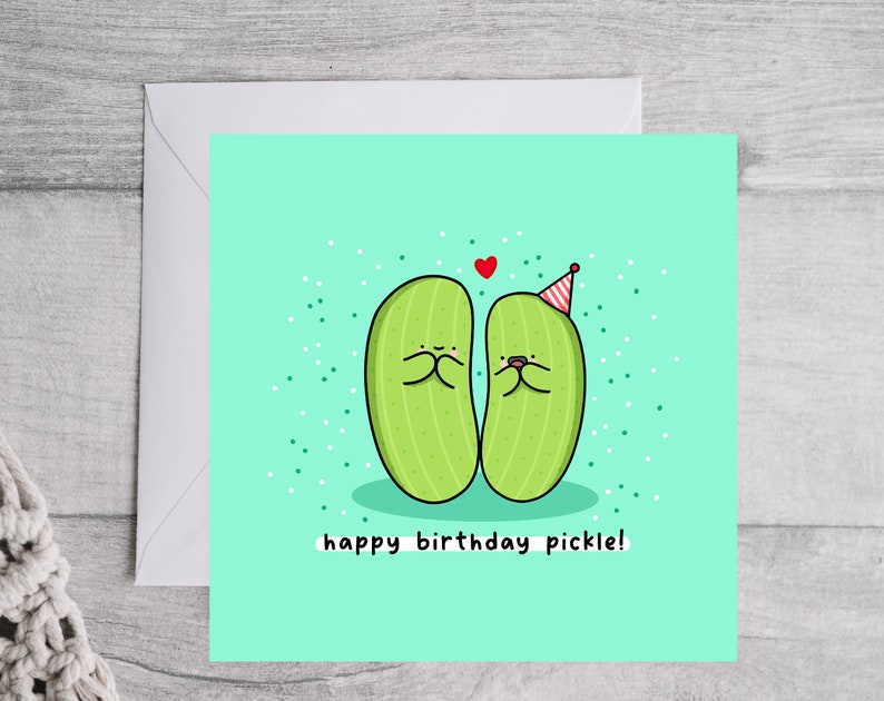 May include: A light green birthday card with two cartoon pickles wearing party hats. The card has the text "happy birthday pickle!" on it.