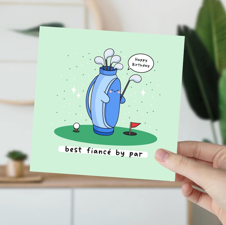 Puede incluir: Tarjeta de felicitaci&oacute;n verde claro con un tema de golf de dibujos animados. La tarjeta presenta una bolsa de golf azul con una cara sonriente, palos de golf, una pelota de golf y una bandera roja. El texto dice "Happy Birthday" y "best fianc&eacute; by par."