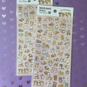 May include: Two sticker sheets featuring various cartoon dog illustrations in different poses. The stickers are in a clear plastic sleeve with the text "MIND WAVE SEALS" and "POTE PUPPY" printed on the top. The background is a purple surface with heart shapes.