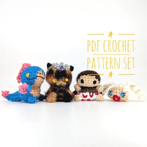May include: Four handmade crochet dolls in different colours are displayed. The dolls include a blue and pink creature, a brown and orange cat-like figure with a crown, a brown doll with a red and white skirt, and a white doll with blue eyes and red lips. The text "PDF CROCHET PATTERN SET" is visible.