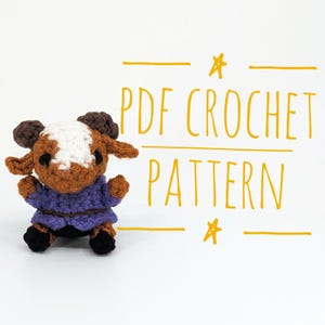 May include: A handmade crochet doll in the shape of a ram, featuring brown, white, and purple yarn. The doll has a purple sweater and black hooves. The image includes the text "PDF CROCHET PATTERN" in orange.