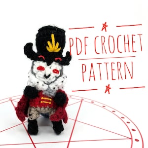 May include: Crochet pattern PDF for a small, black and red amigurumi figure wearing a crown and a tall hat with a yellow feather. The figure is standing on a white background with a red circle and pentagram.