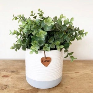 A contemporary grey and white ribbed planter with a leather love tag