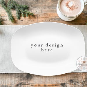 May include: White oval serving platter with the text "your design here" on a wooden table with a white linen runner, a pine branch, and a cup of hot chocolate.