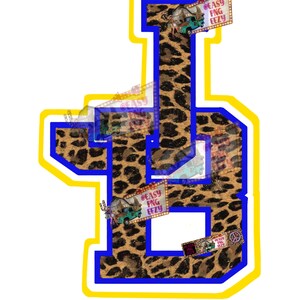 May include: A blue and yellow varsity letter D with a leopard print pattern. The letter is surrounded by a yellow outline and a blue outline. There are several small images of a vintage truck and a barn on the letter.