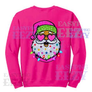 May include: Pink sweatshirt with a glitter design of Santa Claus wearing heart-shaped sunglasses and a string of lights around his beard.