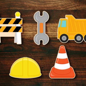 May include: A set of five construction-themed cutouts, including a yellow dump truck, a wrench, a traffic cone, a hard hat, and a yellow and black construction barricade.