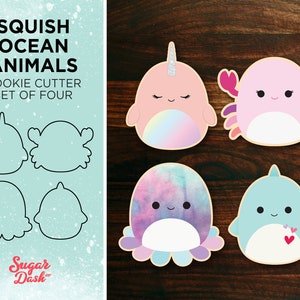 May include: Set of four cookie cutters shaped like ocean animals: a narwhal, a crab, an octopus, and a dolphin. The cutters are shown next to colorful, decorated cookies.