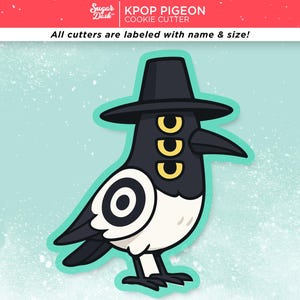 May include: A cartoon cookie cutter in the shape of a black and white bird wearing a black hat. The bird has three yellow eyes and a long black beak. The text "KPOP PIGEON COOKIE CUTTER" is at the top.