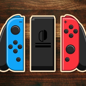 May include: Three Nintendo Switch Joy-Con controllers, one blue, one red, and one black. The black controller is a console.