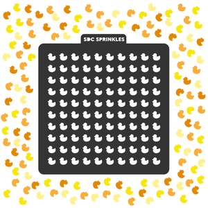 May include: A black stencil with the text "SDC SPRINKLES" at the top. The stencil is filled with a grid of 10 rows and 10 columns of white rubber duck outlines. The stencil is surrounded by a scattering of yellow and orange rubber duck sprinkles.