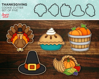 May include: Set of five Thanksgiving cookie cutters. The cutters are shaped like a turkey, a pilgrim hat, a pie, a cornucopia, and a basket of pumpkins. The cutters are made of metal and have a silver finish.