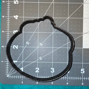 Puede incluir: Cortador de galletas de pl&aacute;stico negro en forma de nube con borde festoneado. El cortador mide aproximadamente 7,5 cm de ancho y 5 cm de alto.