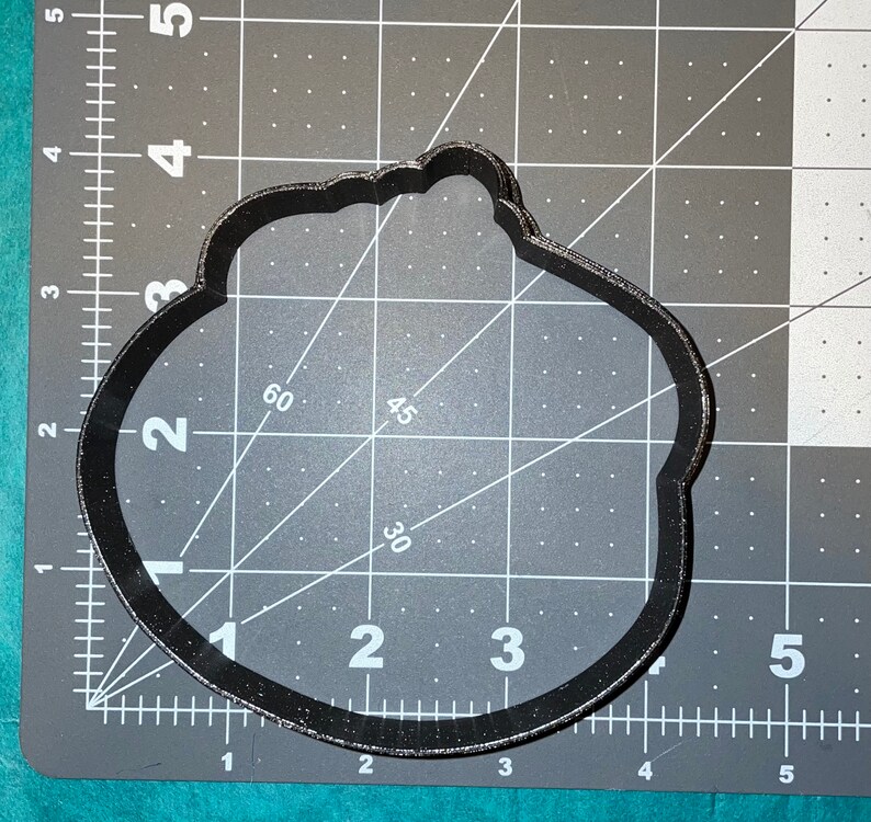 Puede incluir: Cortador de galletas de pl&aacute;stico negro en forma de nube con borde festoneado. El cortador mide aproximadamente 7,5 cm de ancho y 5 cm de alto.