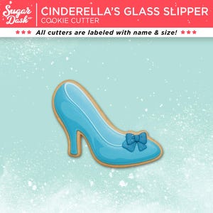 May include: A blue Cinderella's glass slipper cookie cutter with a bow detail. The cookie cutter is outlined in a light brown color. The text "CINDERELLA'S GLASS SLIPPER COOKIE CUTTER" is at the top of the image.