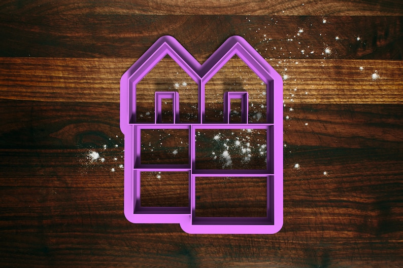 May include: Purple plastic cookie cutter shaped like a two-story house with windows and a door. The cutter is on a wooden surface.