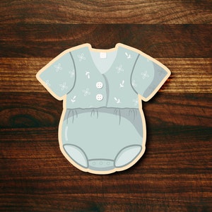 May include: A light blue baby onesie with a white floral pattern and white buttons. The onesie has a snap closure at the bottom.