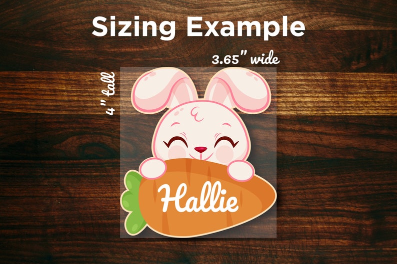 May include: A pink and white bunny rabbit with a big smile holds a carrot in its paws. The carrot is orange and green and has the name "Hallie" written on it. The image is 3.65 inches wide and 4 inches tall.