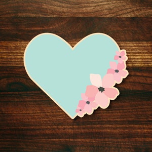 May include: A light blue heart-shaped card with pink flowers on the right side.