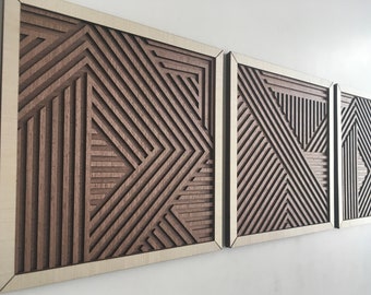 May include: A set of three wooden wall art panels with geometric designs. The panels feature layered, linear patterns in shades of brown and beige, creating a modern, abstract aesthetic. The artwork is framed with a light-colored wood border.